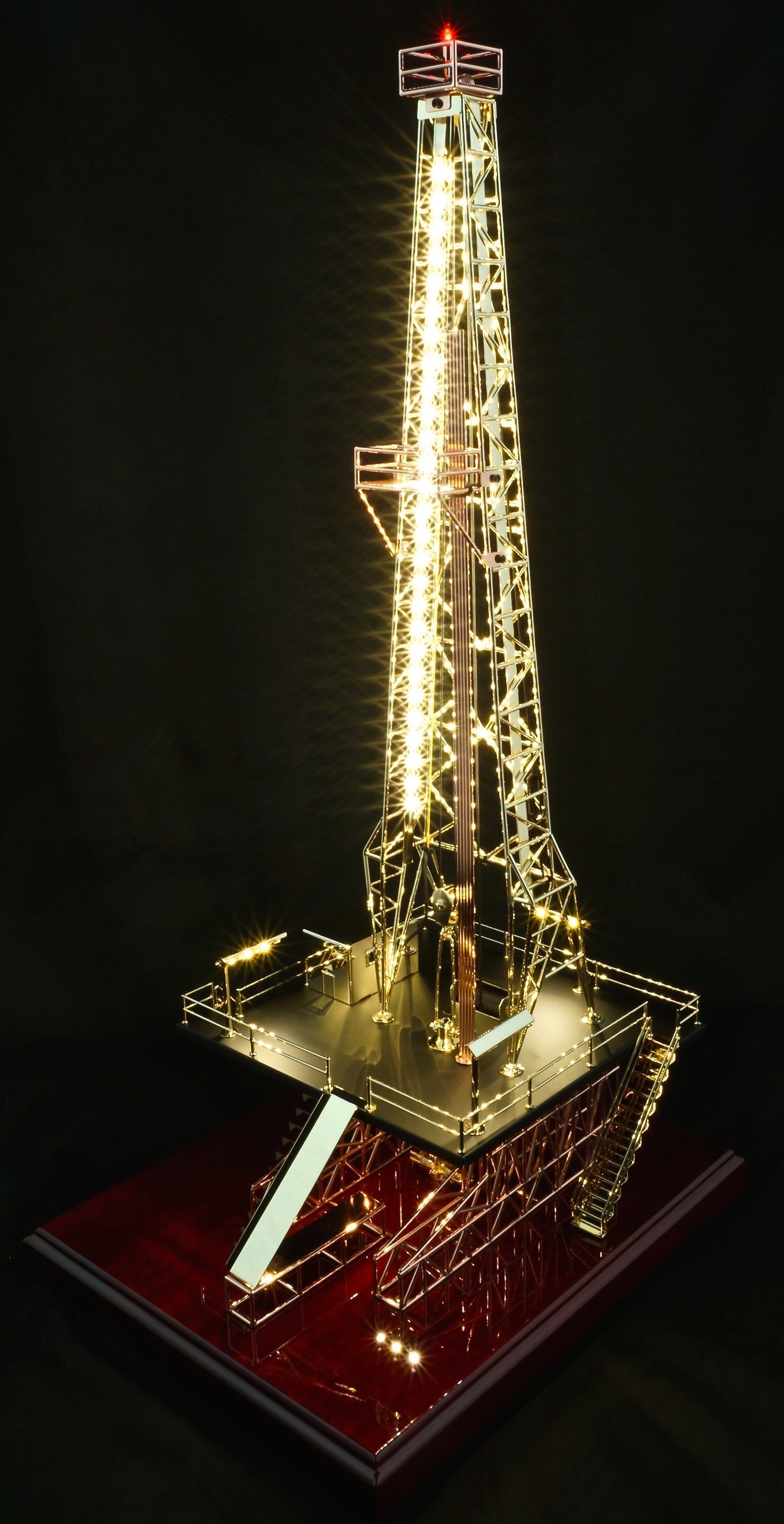 Oilfield drill rig derrick at night with lights